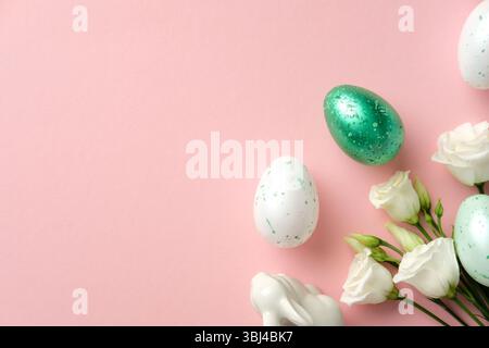 Happy Easter concept. Flat lay composition with speckled eggs, delicate white flowers, and a ceramic on pastel pink background Stock Photo