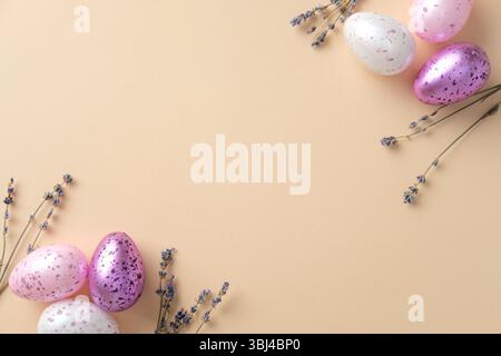 Easter holiday celebration concept. Flat lay composition with purple Easter eggs and lavender on beige background. Stock Photo