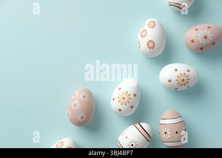 Hand-painted Easter eggs with floral and geometric patterns on pastel blue background Stock Photo