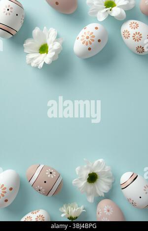 Pastel Easter eggs with floral and striped patterns paired with white daisies on a pastel blue background. Stock Photo
