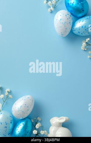 Easter vertical banner design with ceramic bunny, white flowers, speckled blue eggs on a light blue background. Stock Photo