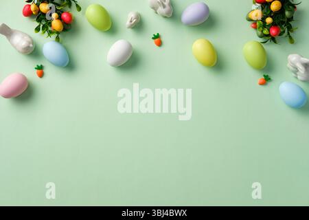 Pastel Easter eggs with decorations on light green background. Flat lay, top view, copy space. Stock Photo