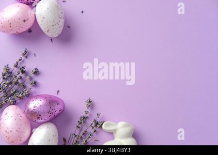 Purple decorated Easter eggs with lavender and bunny. Flat lay, top view. Stock Photo