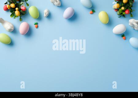 Creative Easter layout with colorful Easter eggs, bunny, and decorations on pastel blue background Stock Photo