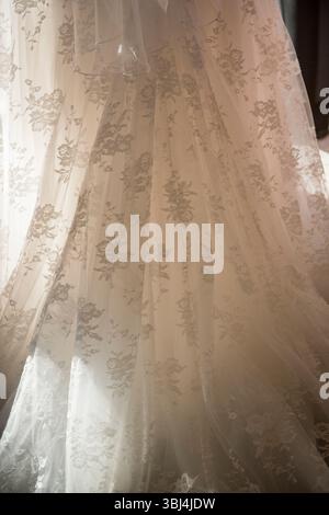 Close-Up of Floral Lace Wedding Gown in Soft Light Stock Photo