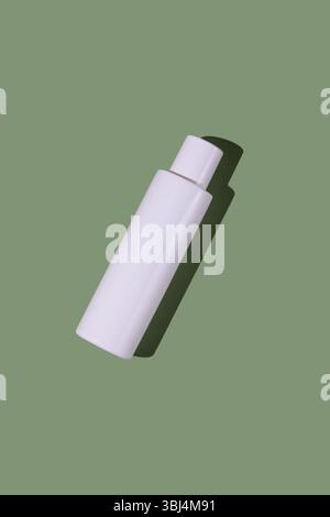 White transparent cosmetics plastic bottle, green background Stock Photo