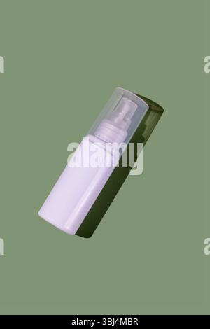 White transparent cosmetics plastic bottle, green background Stock Photo