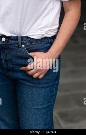close-up of a red heart drawn on a hand with a thumb in a pocket Stock Photo