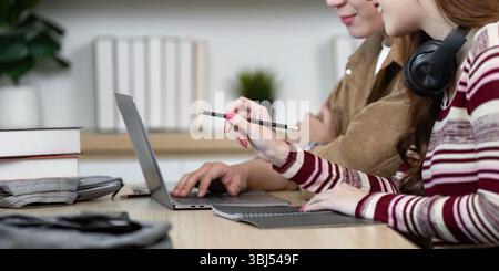 Focused Learning Environment. Students collaborating on laptops while studying. Stock Photo
