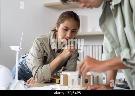 Architects Collaborating on Sustainable Design Project with Model Stock Photo