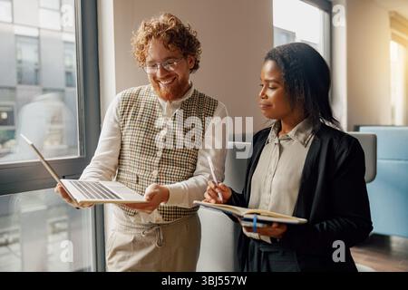Collaborative professionals analyze data on laptops in a modern, innovative office Stock Photo
