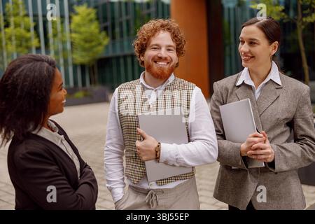 A professional team is seen collaborating successfully outside a modern office building Stock Photo