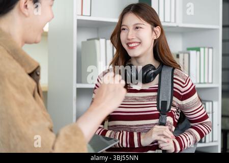 Student Collaboration and Learning. Two university students engaging in a productive discussion with digital tools. Stock Photo