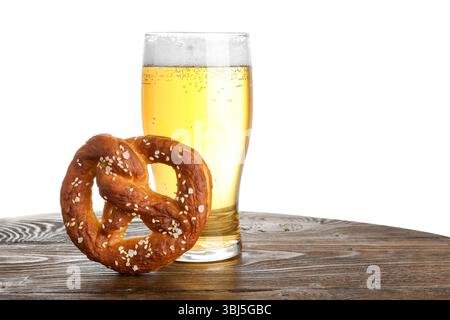 Tasty pretzel and glass of beer on wooden table against white background Stock Photo