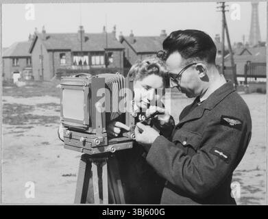 Royal Air Force No. 2 School of Photography, Palatine Road, Blackpool, Lancashire, 1942-1943. An RAF instructor making repairs to a camera during a training exercise for Women's Auxiliary Air Force (WAAF) trainees during the first week of the training programme. The RAF’s No. 2 School of Photography was established in August 1940 to meet the rapidly increasing need for more photographers and photographic technicians to aid with aerial reconnaissance during the WW2. The School was based at the Blackpool Technical College and Palatine Secondary School in Blackpool. Training of women at th Stock Photo