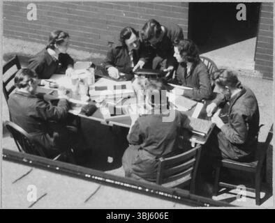 Royal Air Force No. 2 School of Photography, Palatine Road, Blackpool, Lancashire, 1942-1943. An RAF instructor directing a group of Women's Auxiliary Air Force (WAAF) trainees in identifying processing faults on film negatives. The RAF’s No. 2 School of Photography was established in August 1940 to meet the rapidly increasing need for more photographers and photographic technicians to aid with aerial reconnaissance during the WW2. The School was based at the Blackpool Technical College and Palatine Secondary School in Blackpool. Training of women at the School began in 1941. This photo Stock Photo