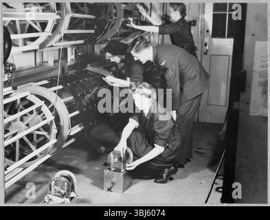 Royal Air Force No. 2 School of Photography, Palatine Road, Blackpool, Lancashire, 1942-1943. An RAF instructor watching as Women's Auxiliary Air Force (WAAF) trainees place photographic films on the drying drums. The RAF’s No. 2 School of Photography was established in August 1940 to meet the rapidly increasing need for more photographers and photographic technicians to aid with aerial reconnaissance during the WW2. The School was based at the Blackpool Technical College and Palatine Secondary School in Blackpool. Training of women at the School began in 1941. This photograph is one of Stock Photo