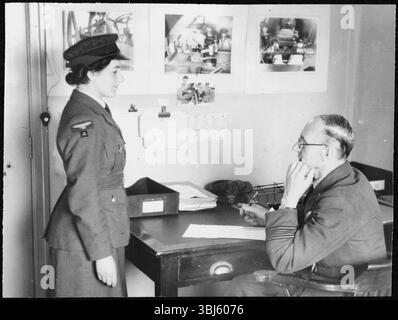 Royal Air Force No. 2 School of Photography, Palatine Road, Blackpool, Lancashire, 1942-1943. A new Women's Auxiliary Air Force (WAAF) trainee being interviewed on her first day by the Commanding Officer, Squadron Leader W H Dunton. The RAF’s No. 2 School of Photography was established in August 1940 to meet the rapidly increasing need for more photographers and photographic technicians to aid with aerial reconnaissance during the WW2. The School was based at the Blackpool Technical College and Palatine Secondary School in Blackpool. Training of women at the School began in 1941. Each t Stock Photo