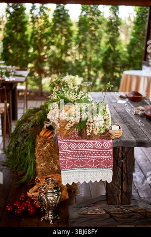 Banquet decoration in a simple rustic style with grass, greenery, simple objects and fabrics. Wedding table setting for guests Stock Photo