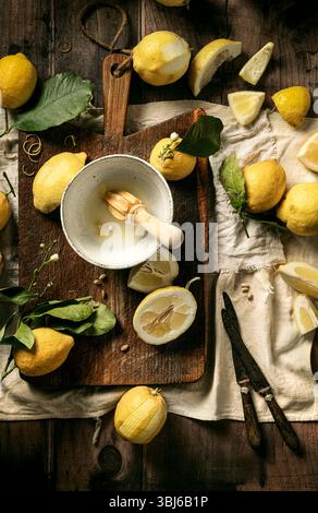 fresh lemons just squeezed on wooden board with leaves Stock Photo