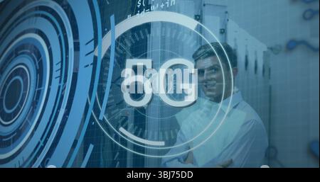 Standing telecom engineer crossing arms in data center with racks, cables and 5G overlay copy space Stock Photo