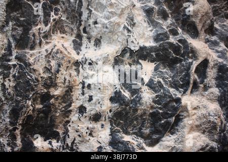 Stone natural texture close-up, black and beige color, background, stone relief, stone structure Stock Photo