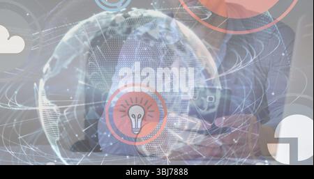 Typing on laptop and smartphone at office desk, projecting globe, lightbulb, cloud, pie chart icons Stock Photo