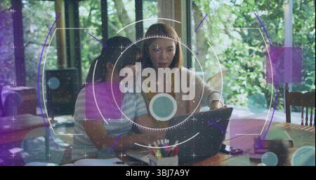 Mother and daughter studying in dining nook, with laptop notebooks colored pencils and black device Stock Photo