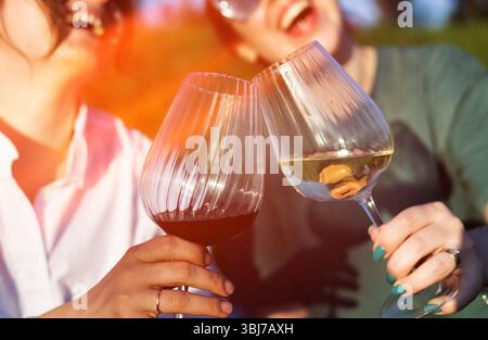 People clinking glasses of wine on a summer terrace of a cafe or restaurant Stock Photo