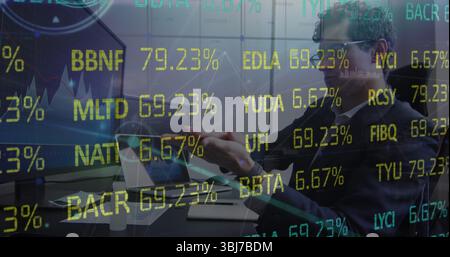 Reviewing charts analyst in sweater typing on laptop with dual monitors at desk, coffee, copy space Stock Photo