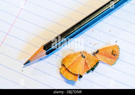 Sharpened pencil and shavings on a blank  notebook lined page Stock Photo