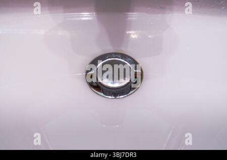 Centered Close-up view of water collecting in a closed washroom sink drain Stock Photo
