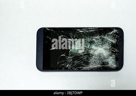 Shattered smart phone screen laying horizontal on a white background Stock Photo