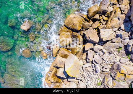 Top Down Drone View of a rocky Beach shore and Rippled Ocean Water Stock Photo