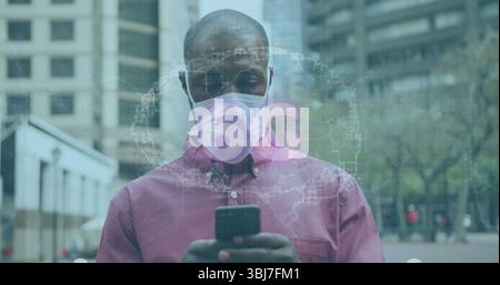 Man wearing pink shirt and mask using smartphone to view 6G holographic map in urban plaza Stock Photo