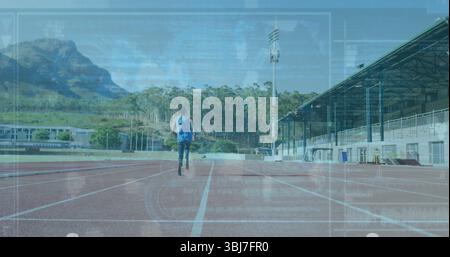 Running male teenager wearing blue hoodie on red rubber track with backpack and white lane markers Stock Photo