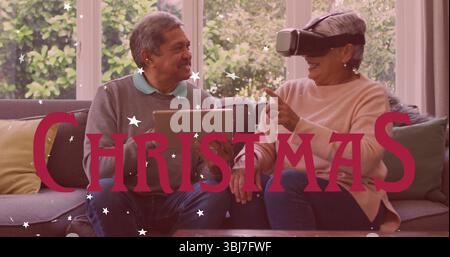 Smiling senior Asian couple exploring virtual reality and tablet in living room, with throw pillows Stock Photo
