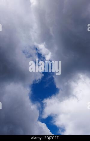 Patch of blue sky behind dark gray clouds, Finland Stock Photo