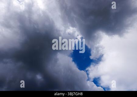 Glimpse of blue sky behind dark gray clouds, Finland Stock Photo