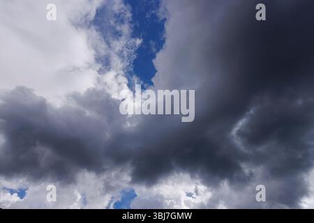 Glimpse of blue sky behind dark gray clouds, Finland Stock Photo