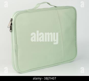 Soft green laptop sleeve features zippered closure and sturdy handle for easy carrying. Perfect for travel. Stock Photo