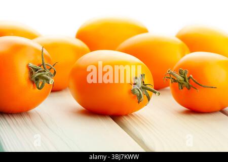 orange plum tomato on wood background on white Stock Photo