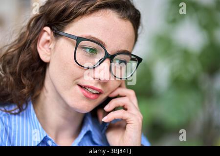 Young woman talking on the phone working in office. Close up Stock Photo