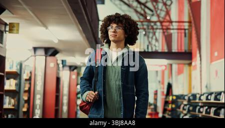 Thinking, university and student or man in library for learning, research project or study vision. College reflection, scholarship opportunity and Stock Photo