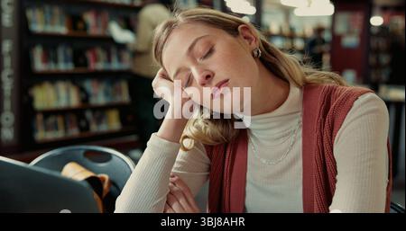 College student, laptop and girl with sleeping in library for study fatigue, burnout or low energy. Education, tired and person with nap on campus for Stock Photo