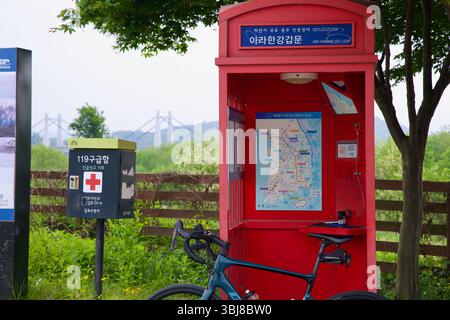 Incheon, South Korea - May 19th 2025: A red certification booth marks the start of the Ara Bicycle Path at Ara Hangang Lock, where cyclists stamp thei Stock Photo