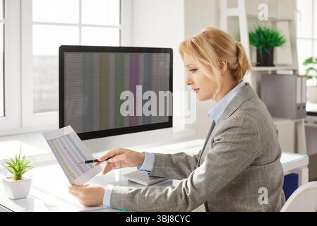 Financial accountant analyzing financial report and accounting data and reviewing spreadsheet. Stock Photo