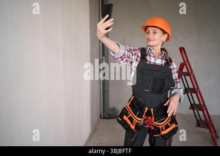 Female builder or architect having video call at construction site Stock Photo