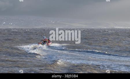 RNLI launches inshore rescue boat during Storm, south Wales coast UK Stock Photo