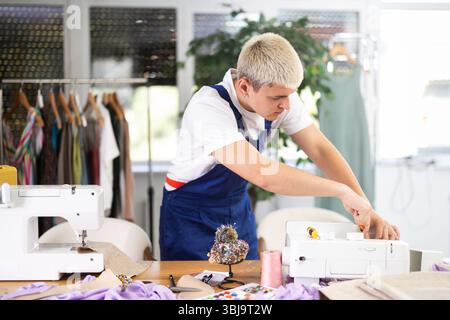 Repairman repairing sewing machine in workshop Stock Photo